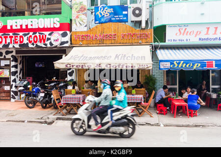Unità motociclisti passato ristoranti su Bui Vien Street, Città di Ho Chi Minh (Saigon), Vietnam Foto Stock