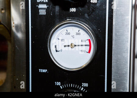 Bianco del sensore di temperatura sul piano industriale sporca di metallo nero di forno in cucina di un bar o un ristorante mostra una temperatura di quattrocento fithty deg Foto Stock