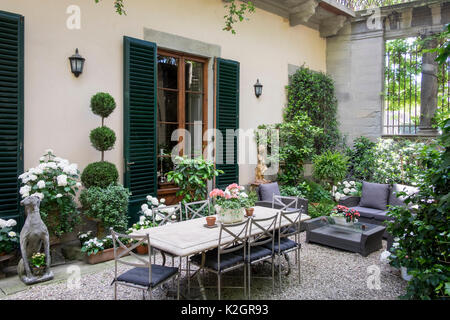 Palazzo Malenchini, Firenze, Italia, elegante cortile interno con giardino e topiaria da e mobili da pranzo Foto Stock