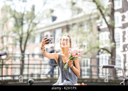 Donna con fiori in Amsterdam City Foto Stock