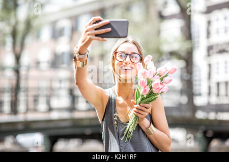 Donna con fiori in Amsterdam City Foto Stock