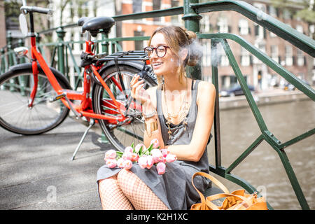 Donna di fumare in Amsterdam City Foto Stock