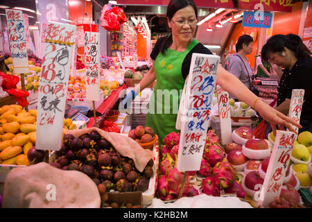 La donna per la vendita di frutta a Hong Kong nel mercato Foto Stock