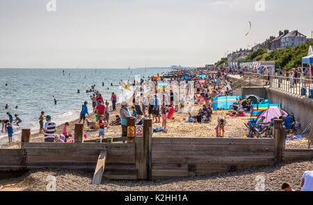 Southwold, Suffolk, Regno Unito, spiaggia cercando occupato al hightide d'estate. Foto Stock