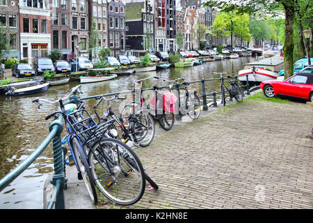 Amsterdam, Paesi Bassi - 9 Settembre 2011: biciclette, auto e barche lungo un canale di Amsterdam Foto Stock