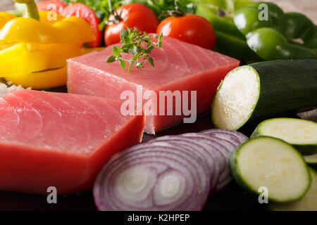 Materie bistecche dal tonno e verdure fresche, spezie close-up. sfondo orizzontale Foto Stock