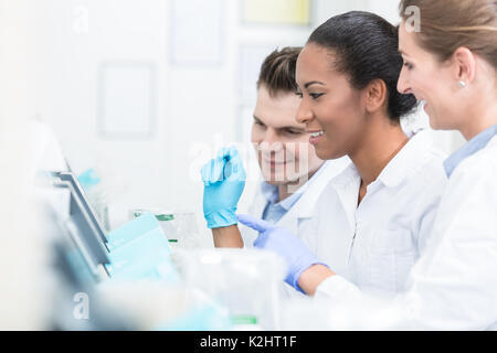 Un gruppo di ricercatori durante il lavoro sui dispositivi in laboratorio Foto Stock