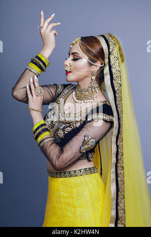 Ritratto di bella ragazza indiana . Giovane donna indù modello su sfondo blu con la kundan gioielli . Tradizionale costume indiano per matrimonio lehenga ch Foto Stock