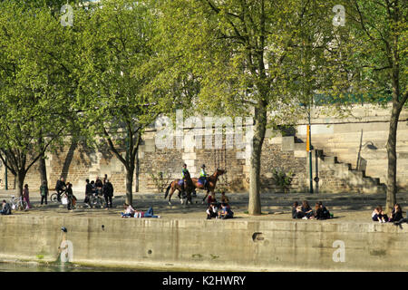 Le persone a rilassarsi sulla parete lungo il Fiume Senna a Parigi, Francia. Foto Stock