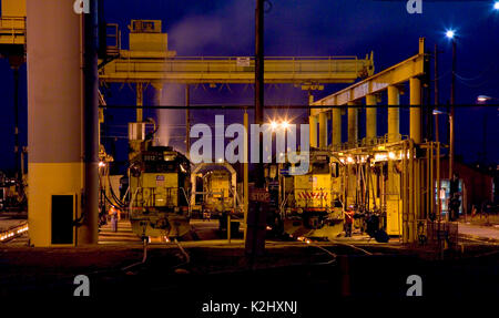 Trasporto merci Diesel locomotive sono allineati in corrispondenza di un outdoor cantiere ferroviario manutenzione e facilità di lavaggio Roseville, CA. Nota carroponte e fumo di scarico. Foto Stock