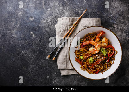 Udon Noodles saltati in padella con la tigre di gamberetti e vegetale in ciotola su sfondo scuro spazio copia Foto Stock