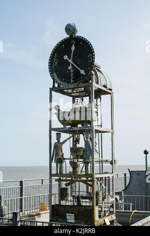 L'orologio sul molo di Southwold Suffolk termina con un grande orologio di stile meccanico che si affaccia sul metallo dell'acqua di mare all'esterno del soldato e guarda le mani Foto Stock