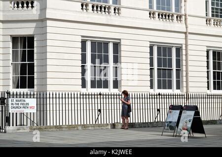 Donna su un telefono cellulare in un paesaggio urbano, London REGNO UNITO Foto Stock