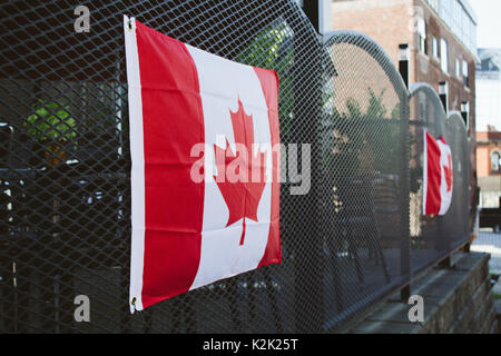 Bandiere canadesi appeso alla recinzione in città Foto Stock