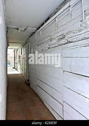 Un antico vicolo pannellate di legno e dipinti di bianco, che conduce ad un cortile, off Carter Lane, London EC4 Foto Stock