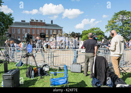 Un news reporter e cameraman con un pezzo alla telecamera fuori dalle porte di Kensington Palace. Per commemorare la Principessa Diana, venti anni dopo la sua morte. Foto Stock