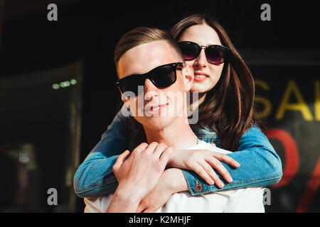 Uomo bello carring la sua ragazza sorridente sul retro. Foto Stock