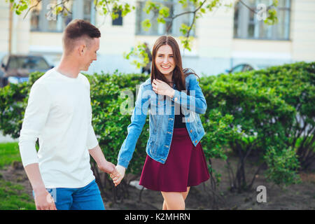 Coppia di turisti facendo una passeggiata in una strada di città marciapiede in una giornata di sole Foto Stock