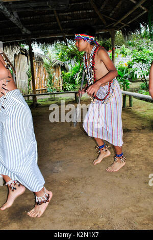 Un gruppo di uomini Shuar dancing. Essi indossano accessori fatta di semi nel suo corpo. Comunità Shuar. Bucay. Proviince di Guayas. Ecuador Foto Stock