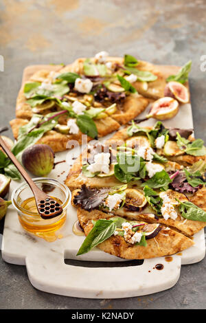 Flatbread rientrano la pizza con il balsamico, fichi, formaggio e foglie di insalata Foto Stock