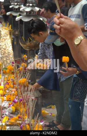 Accendendo candele e pregando a Wat Phra Mahathat Woramahawihan, il tempio buddista principale della provincia di Nakhon si Thammarat nel sud della Thailandia. Foto Stock