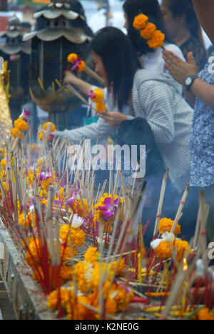 Accendendo candele e pregando a Wat Phra Mahathat Woramahawihan, il tempio buddista principale della provincia di Nakhon si Thammarat nel sud della Thailandia. Foto Stock