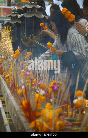 Accendendo candele e pregando a Wat Phra Mahathat Woramahawihan, il tempio buddista principale della provincia di Nakhon si Thammarat nel sud della Thailandia. Foto Stock