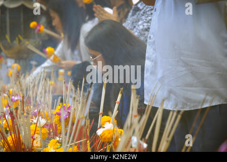 Accendendo candele e pregando a Wat Phra Mahathat Woramahawihan, il tempio buddista principale della provincia di Nakhon si Thammarat nel sud della Thailandia. Foto Stock