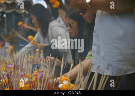 Accendendo candele e pregando a Wat Phra Mahathat Woramahawihan, il tempio buddista principale della provincia di Nakhon si Thammarat nel sud della Thailandia. Foto Stock