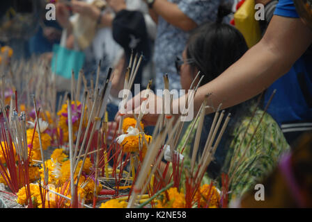 Accendendo candele e pregando a Wat Phra Mahathat Woramahawihan, il tempio buddista principale della provincia di Nakhon si Thammarat nel sud della Thailandia. Foto Stock