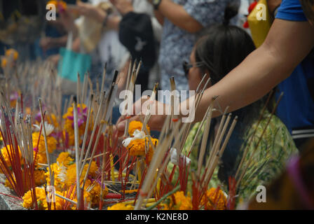 Accendendo candele e pregando a Wat Phra Mahathat Woramahawihan, il tempio buddista principale della provincia di Nakhon si Thammarat nel sud della Thailandia. Foto Stock