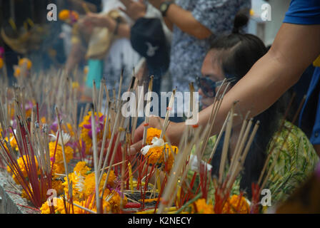 Accendendo candele e pregando a Wat Phra Mahathat Woramahawihan, il tempio buddista principale della provincia di Nakhon si Thammarat nel sud della Thailandia. Foto Stock