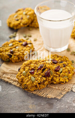 La prima colazione i fiocchi d'avena i biscotti con purea di zucca, il mirtillo palustre e semi con latte Foto Stock