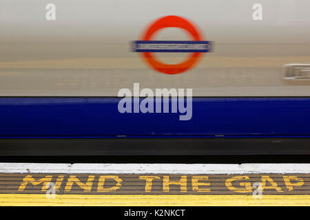 Segnale di avvertimento mente il divario sulla piattaforma da una Londra la stazione della metropolitana di Londra, Inghilterra, Regno Unito Foto Stock