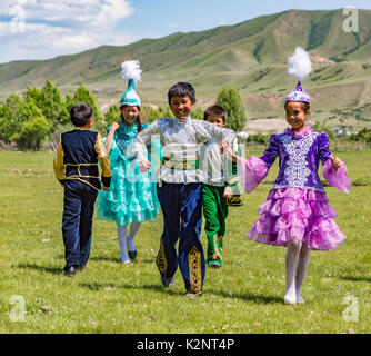 I bambini di giocare una partita in un campo, indossando i costumi tradizionali in Kazakistan il 3 giugno 2017 Foto Stock