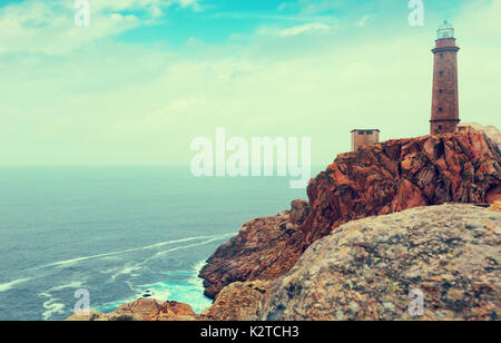 Imitazione di vintage foto con il faro sulla costa rocciosa. Faro di Vilan (Faro de Cabo Vilan). La Galizia, Spagna Foto Stock