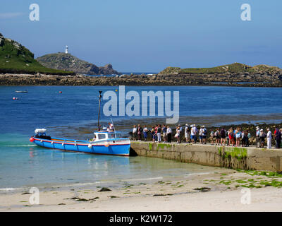 La Stella Polare preleva i visitatori giornalieri dalla città bassa quay, St Martin's, isole Scilly, con lo sfondo dell'isola di Tean e round Island li Foto Stock