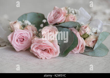 Appassiti dusky rose rosa e le ampie foglie bouquet, su una tavola dopo la cerimonia di nozze Foto Stock