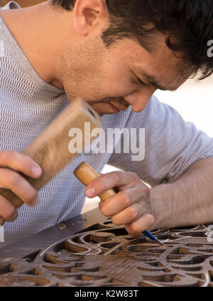 L'uomo scalpelli incisione su legno in officina vicino Bazaar Chorsu a Tashkent, Uzbekistan il 18 maggio 2017 Foto Stock