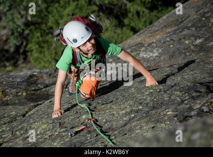 Un giovane ragazzo arrampicata su lastre al Burghutte in Fieschertal Foto Stock