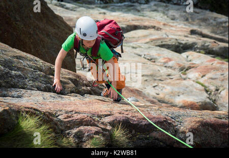 Un giovane ragazzo arrampicata su lastre al Burghutte in Fieschertal Foto Stock