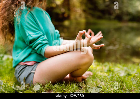 Ragazza irriconoscibili le pratiche yoga al mattino foresta. Foto Stock