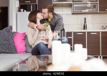 Coppia giovane kissing sul divano Foto Stock