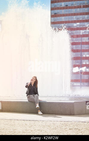 Donna sorridente dall'acquedotto Foto Stock