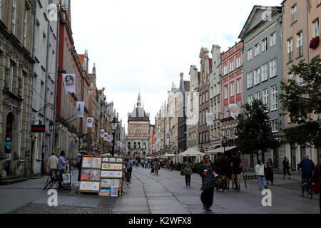 Pedoni vagare passato bancarelle su Dluga Street, la principale arteria che attraversa la Città Vecchia di Danzica, Polonia, il 20 agosto 2017. Il Golden Gat Foto Stock