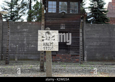 Un segno di persone di avvertimento di arresto, in corrispondenza del bordo del campo di concentramento nazista di Auschwitz, vicino alla città di Oświęcim, Polonia, il 25 agosto 2017. Foto Stock