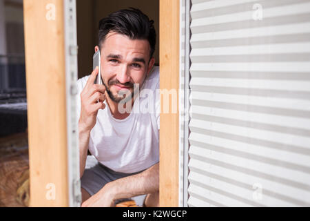 Attraente uomo che parla al telefono Foto Stock