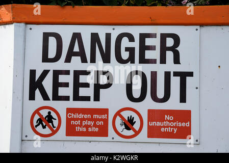 Pericolo segnale "keep out". Avviso relativo al sito dell'edificio. Nessun ingresso non autorizzato. I bambini non devono giocare su questo sito. Southend, Essex, Regno Unito Foto Stock