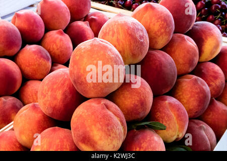 Scatole di legno con pesche al mercato. Foto Stock