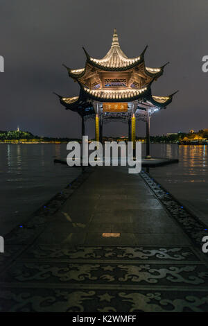 Una delle icone del West Lake, Hangzhou, Cina. Un due-tier pagoda del tetto su una piccola strada rialzata nel famoso lago Foto Stock